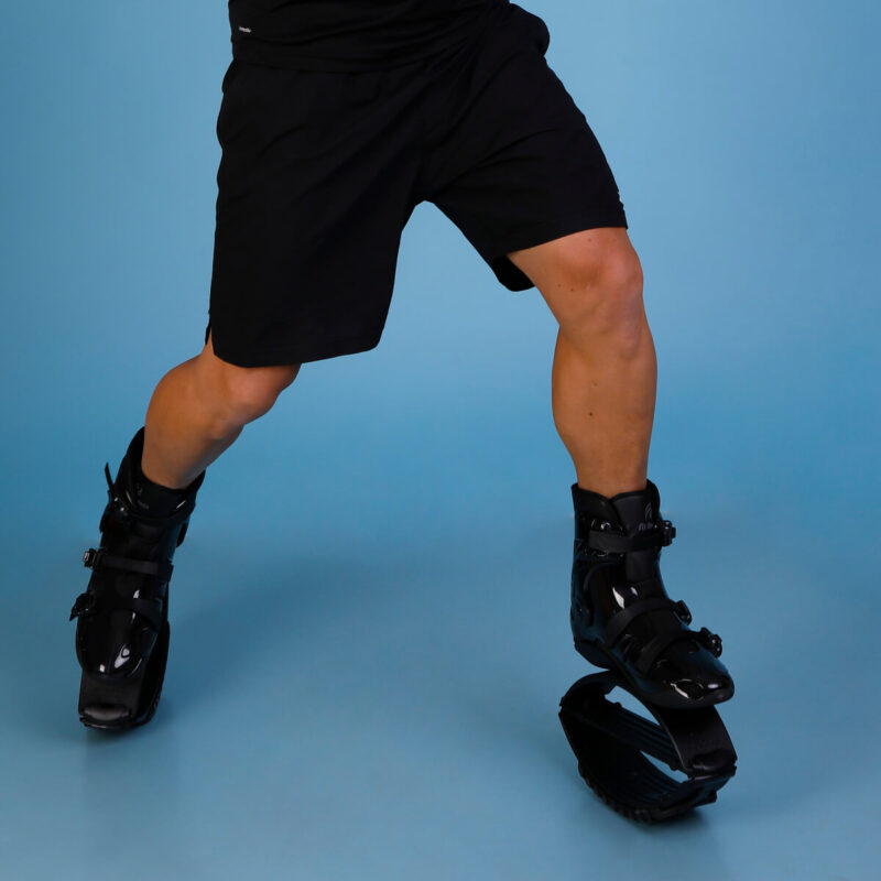 Person standing in a dynamic pose while wearing Fit Boots Rebound Boots