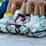 Close-up of multiple people sitting on a bench, showing their Fit Boots Rebound Boots in various colors."